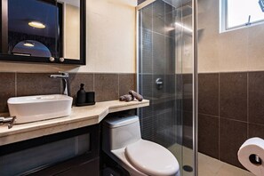 Ein modernes Badezimmer mit Waschbecken, Toilette und einer Duschkabine aus Glas.