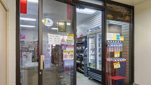 A store with a glass door, a sign indicating business hours, and a refrigerated display case. - Luxe Island Retreat – Modern Coastal Design (Honolulu)