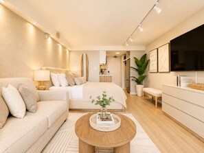 A modern bedroom with a bed, bedside tables, a TV, and a large window. - 41F Modern Waikiki Retreat – Luxe Coastal Style (Honolulu)