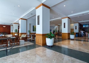 A hotel lobby with a check-in area, seating arrangements, and a reception desk. - Waikiki Ocean Breeze Escape: Coastal Luxe (Honolulu)