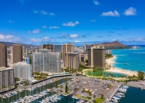 A coastal cityscape with high-rise buildings, a marina, and a beach. - Waikiki Ocean Breeze Escape: Coastal Luxe (Honolulu)