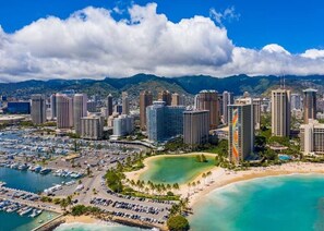 Un paysage urbain côtier avec de hauts immeubles, une marina et une plage.