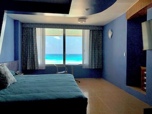 Ein Hotelzimmer mit einem Bett, einem Sessel und Blick auf den Ozean.