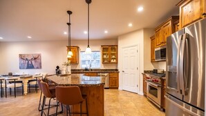 Una cucina moderna con ripiani in granito, elettrodomestici in acciaio inox e mobili in legno.