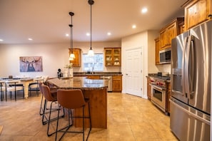 Eine moderne Küche mit Granit Arbeitsplatten, Edelstahlgeräten und Holzschränken.