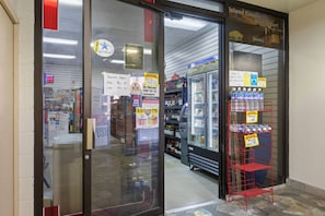 En butiksindgang med et skilt, der angiver åbningstider, et 'SWAP EBT'-skilt og et 'TRYK'-skilt.
