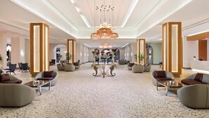 A spacious lobby with a central decorative table, seating areas, and a modern chandelier. - Pickalbatros Portofino Villaggio Resort (Marsa Alam)