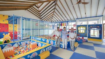 An indoor play area with colorful play structures, a ball pit, and a slide.