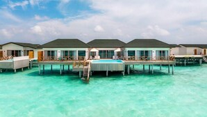 Overwater bungalows with a swimming pool, connected by walkways.