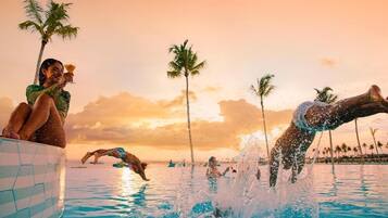 A poolside scene with palm trees and a sunset.