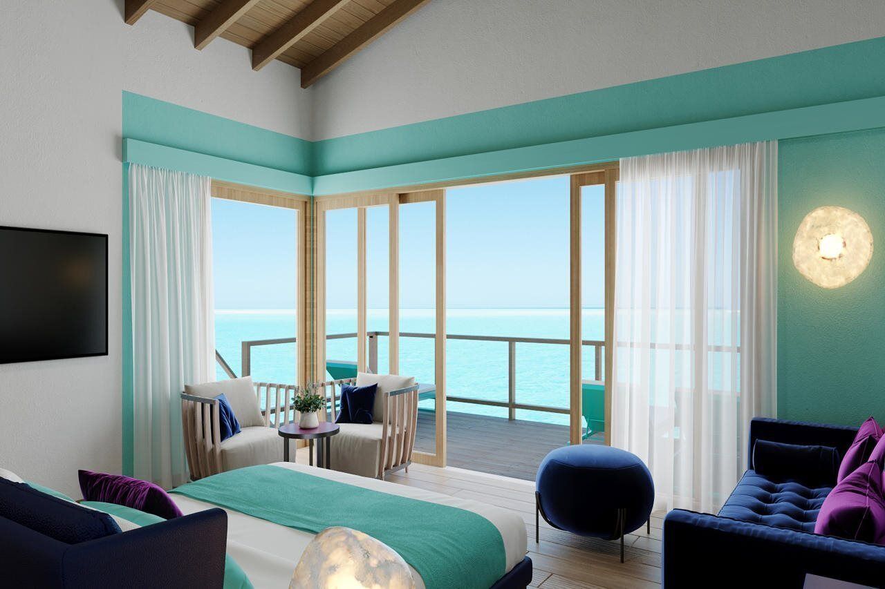 Una habitación de hotel con un ventanal grande, una cama, un sofá, una silla y una mesita.