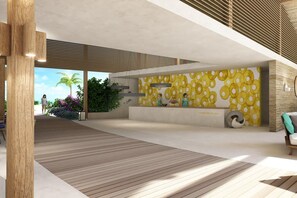 A modern reception area with a wooden floor, a wall with circular patterns, and a view of a beach.