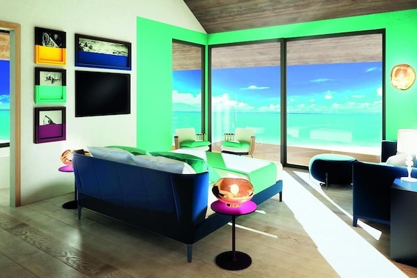A modern room with a bed, a sofa, and a view of the sea through large windows.