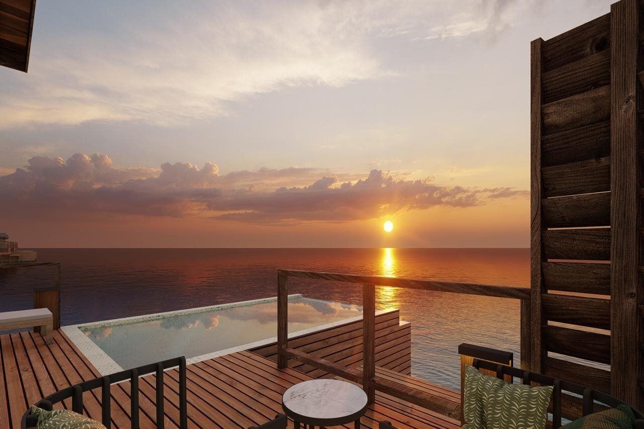 Terraza de madera con piscina y vistas al atardecer.