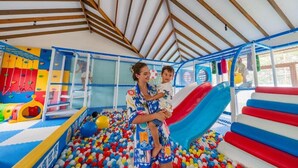 An indoor play area with a ball pit, slides, and climbing structures.