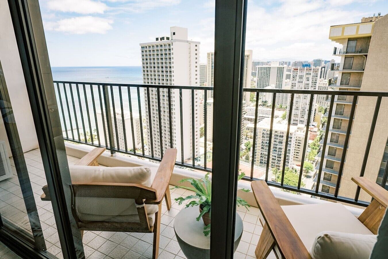 A balcony with a view of a cityscape and the ocean.