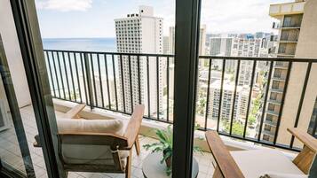 A balcony with a view of a cityscape and the ocean.