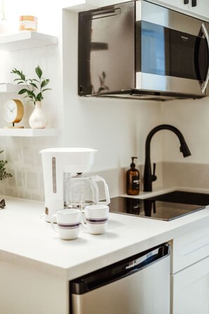 A modern kitchen with a microwave, coffee maker, and a dishwasher. - Modern Waikiki Studio Oasis (Honolulu)