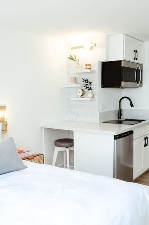Una kitchenette compacta con microondas, fregadero y lavavajillas.