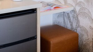 Ein Zimmer mit Kaffeemaschine, Spiegel, Bücherregal und Wand mit Muster.