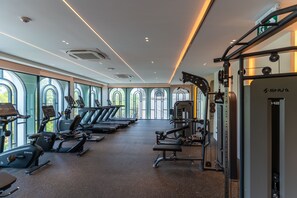 Ein Fitnessstudio mit Laufbändern, Crosstrainern und Gewichten.