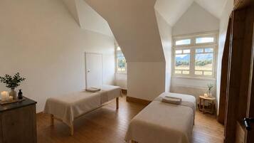 Una habitación con dos camas, un aparador de madera y una ventana con vistas.