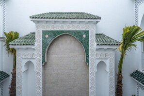 A traditional archway with a tiled roof and decorative elements. - Riad Bab el Qamar (Marrakech)