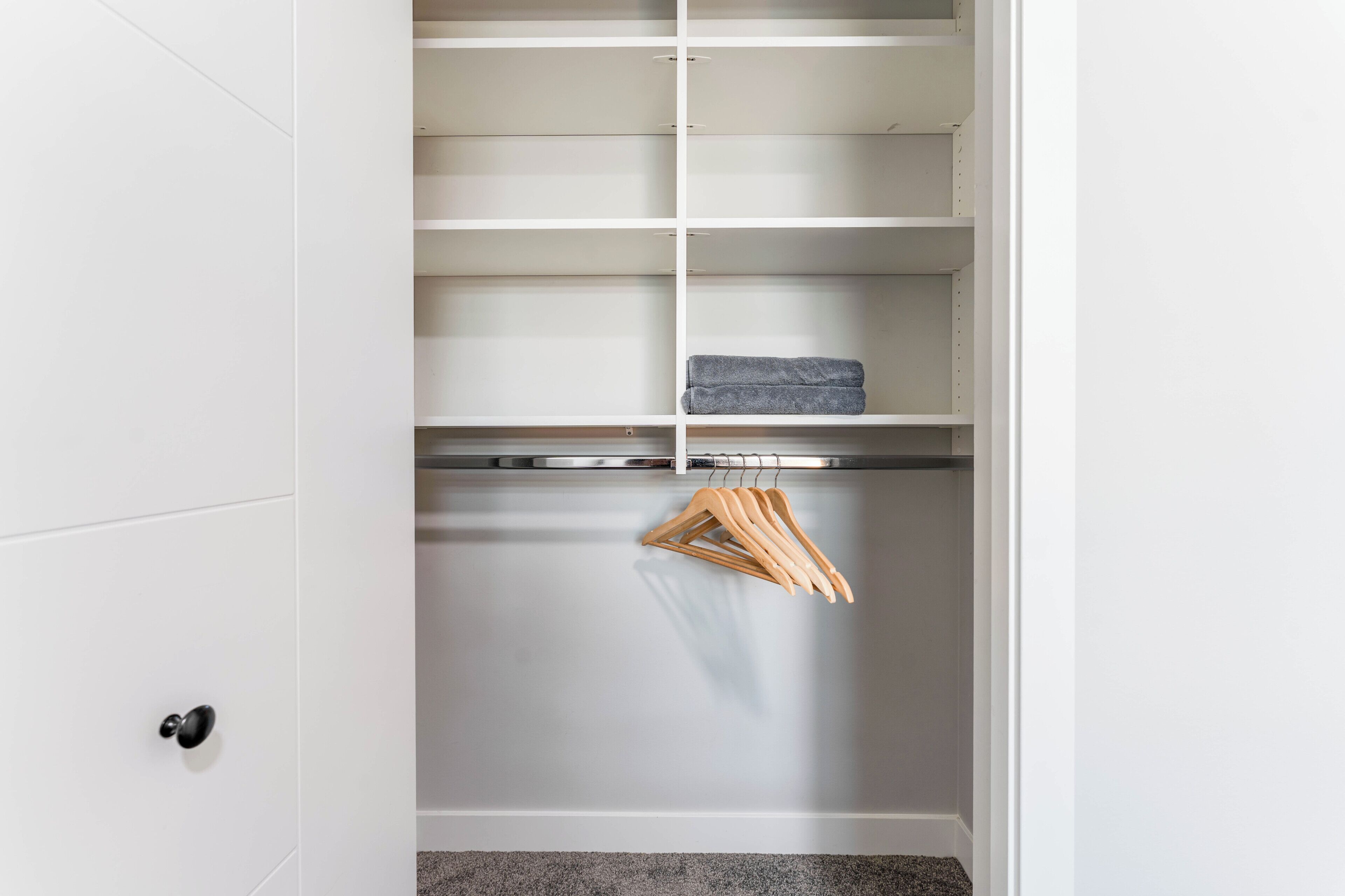 Een kast met meerdere planken en een kledingroede.