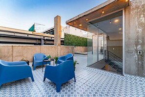 A rooftop terrace with blue chairs, a small table, and potted plants. - Roma Norte Penthouse, Rooftop & Skyline Views (Mexico City)