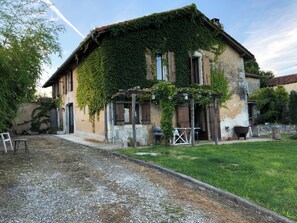A rustic building with ivy-covered walls, a gravel driveway, and a grassy yard. - Traditional 19th century stone farmhouse sympathetically restored with views. (Saint-Martial-Viveyrol)