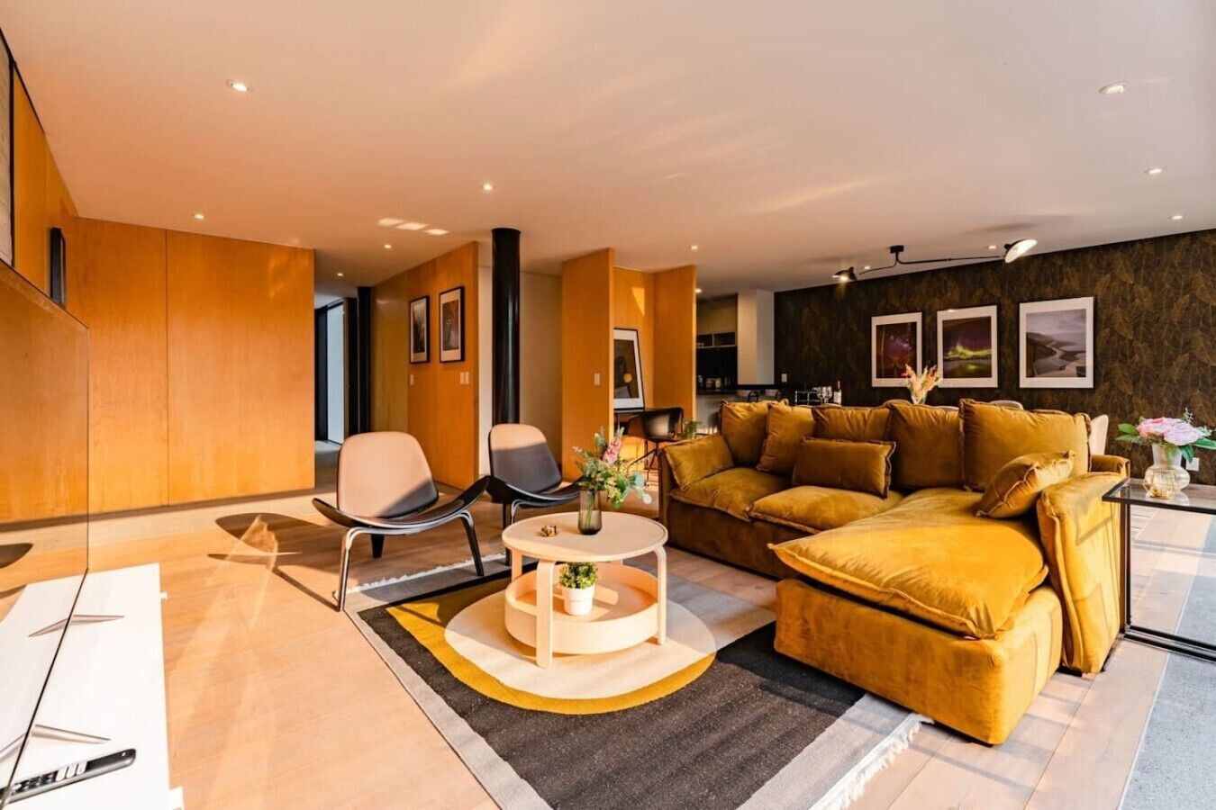 A modern living room with a sofa, chairs, a coffee table, and artwork on the walls.