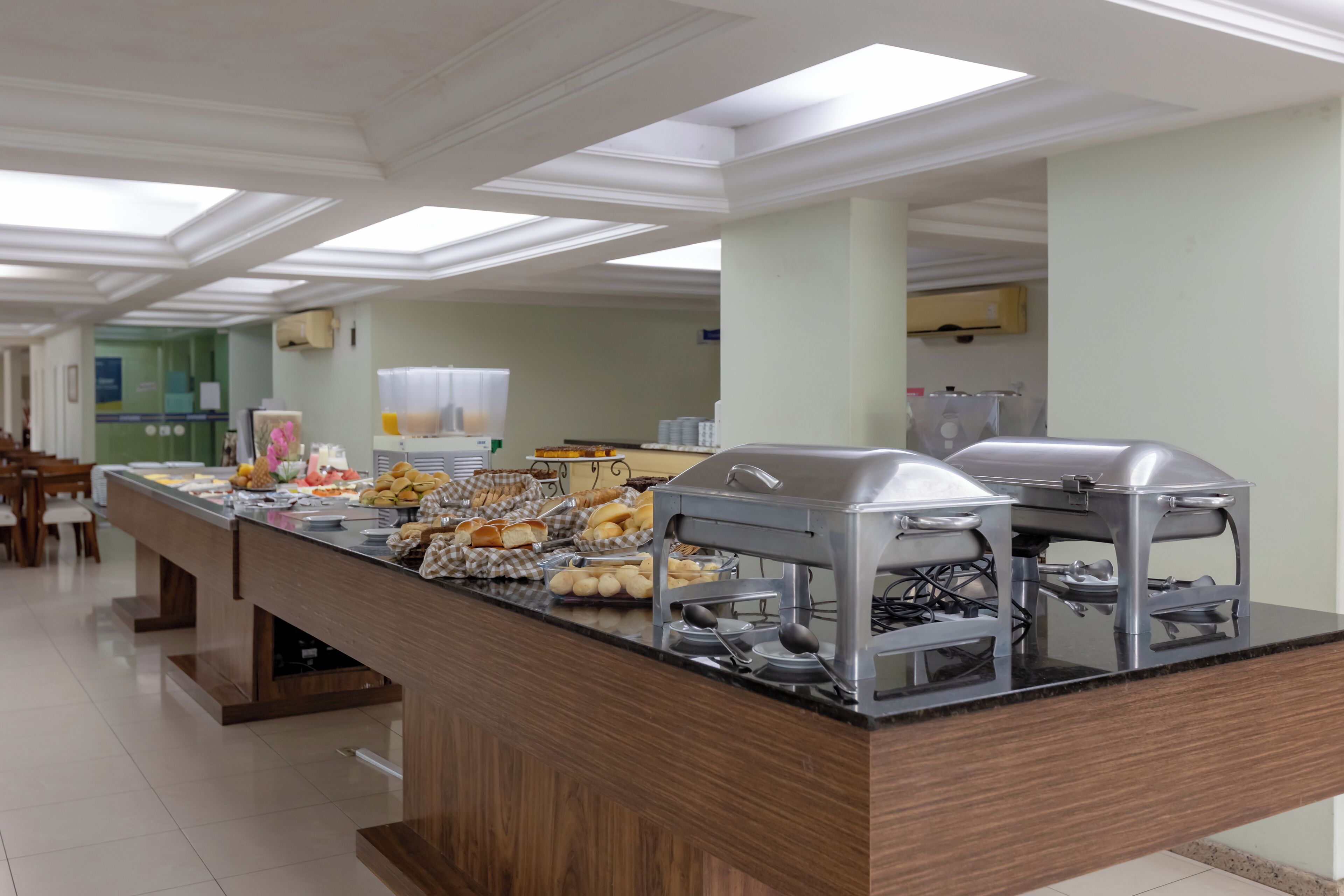 A buffet setup with various food items and a self-service beverage dispenser.