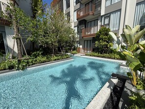 Ein Schwimmbad, umgeben von üppiger Vegetation und moderner Architektur.