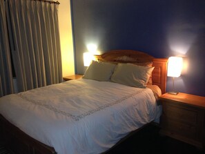 A hotel room with a bed, two bedside lamps, a nightstand, and a curtain. - Santa Monica two bedroom apartment SM5 (Santa Monica)