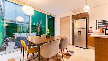 A modern kitchen with a built-in refrigerator and a dining area with a table and chairs.