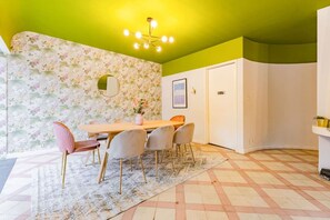Un comedor con una mesa, sillas y un papel tapiz floral.