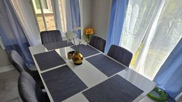 A dining area with a long table, dark chairs, and a vase with flowers.