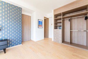A room with a patterned wall, a wardrobe with multiple compartments, and a framed picture on the wall. - City Views & Private Terrace in Trendy Roma (Mexico City)