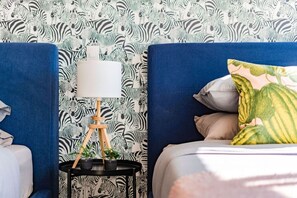 A bedroom with a zebra-patterned wallpaper, a bedside table with a lamp, and a bed with pillows. - City Views & Private Terrace in Trendy Roma (Mexico City)