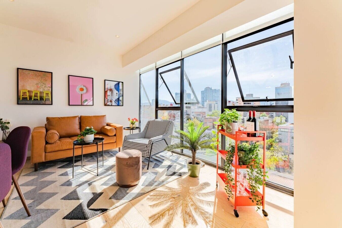 A modern living room with a sofa, armchair, and a plant shelf.