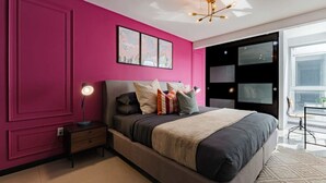 Een moderne slaapkamer met een groot bed, een nachtkastje met een lamp en een raam met uitzicht.