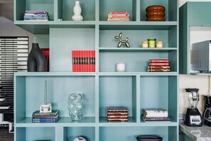 A teal-colored bookshelf with various items including books, a decorative sculpture, and a blender. - Private Terrace Escape in the Heart of Roma Norte (Mexico City)