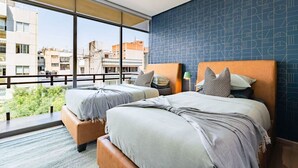 A hotel room with two beds, a large window, and a view of the cityscape. - 2 Condos in La Roma | Parking, Perfect for Groups (Mexico City)