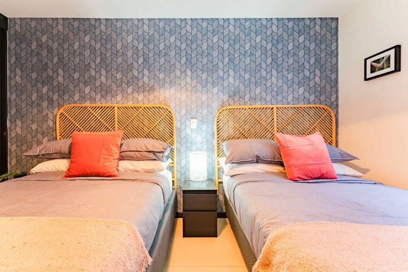 A double room with two beds, each with a headboard, a bedside table, and a nightstand.