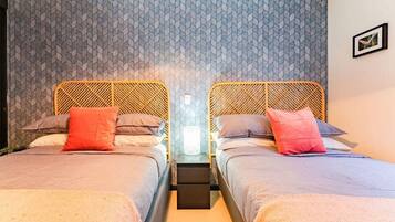 A double room with two beds, each with a headboard, a bedside table, and a nightstand.