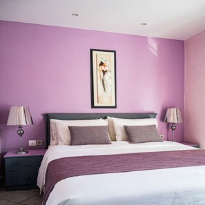 A bedroom with a bed, two bedside tables, and a wall-mounted artwork. - Aloe Boutique Hotel Powered by Anissa Beach (Hersonissos)