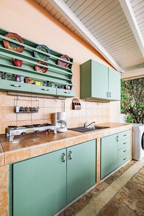 A kitchen with green cabinets, a coffee maker, and a gas stove. - Aloe Boutique Hotel Powered by Anissa Beach (Hersonissos)