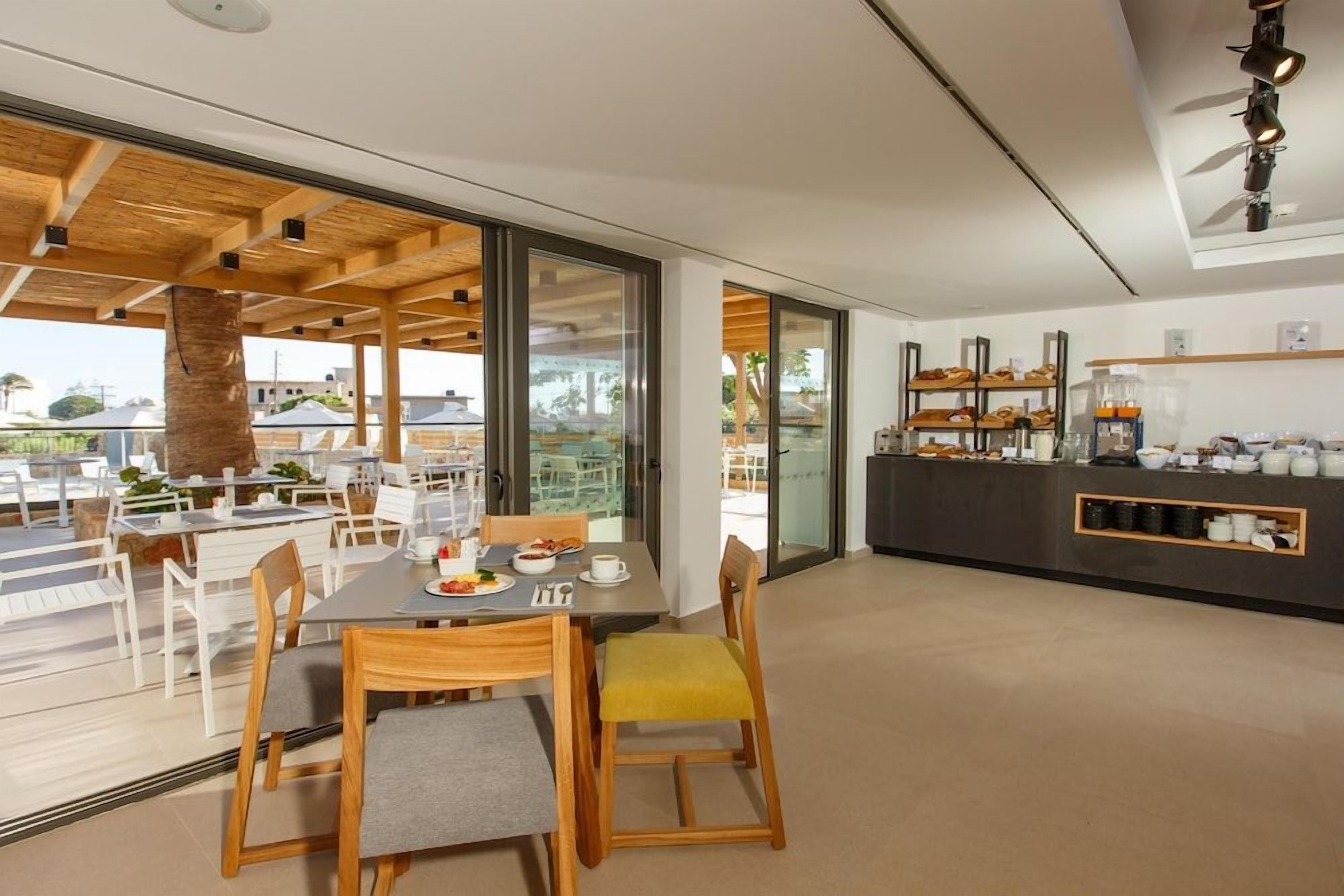 A modern dining area with a view, featuring a bar and kitchen area.