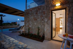 A stone exterior wall with a glass door leading to a modern interior. - Aloe Boutique Hotel Powered by Anissa Beach (Hersonissos)