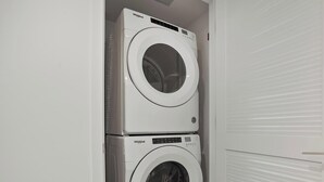 A laundry room with two stacked Whirlpool front-loading washing machines. - Bay-View High-Rise: Priv Balcony, Pool & Gym (Miami)